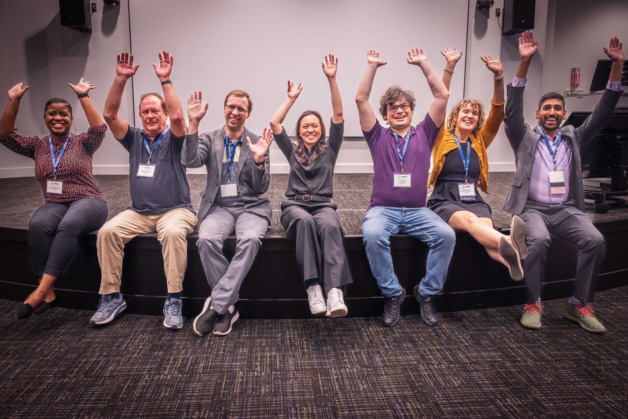 OMSCS faculty and staff and Kathy Pham raising their hands