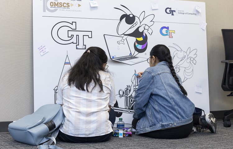 Two attendees coloring a poster together