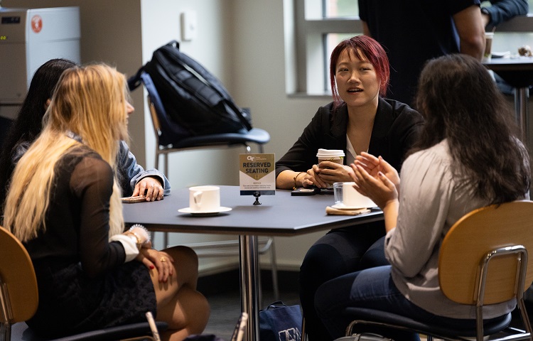 People seated around a table drinking coffee