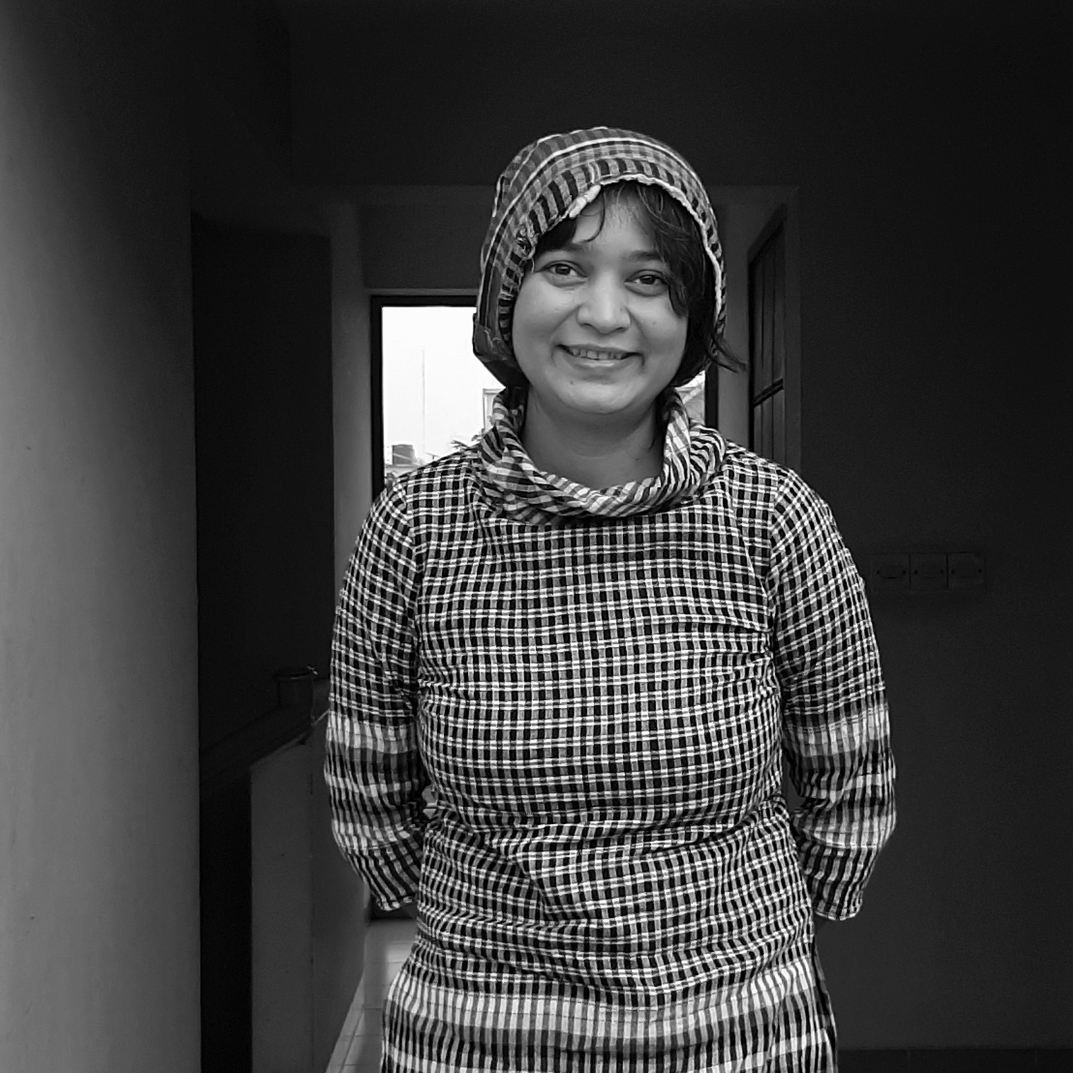 Black and white photo of Nova Ahmed wearing a checkered shirt