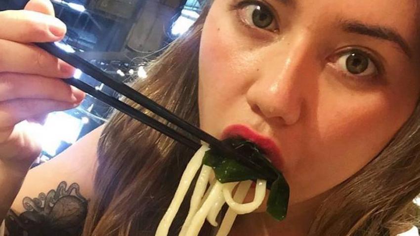 Selfie of Jennifer Georgevich in Singapore eating noodles with chopsticks