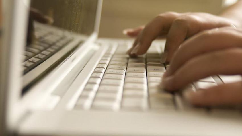 Hands typing on a laptop keyboard