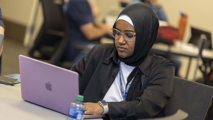 2024 OMSCS Conference attendee working on a laptop