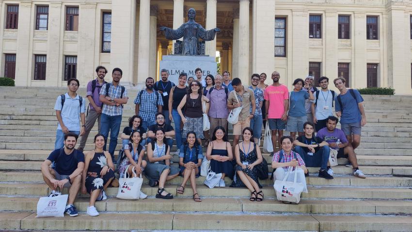 Students on the steps in front of a statue and university building