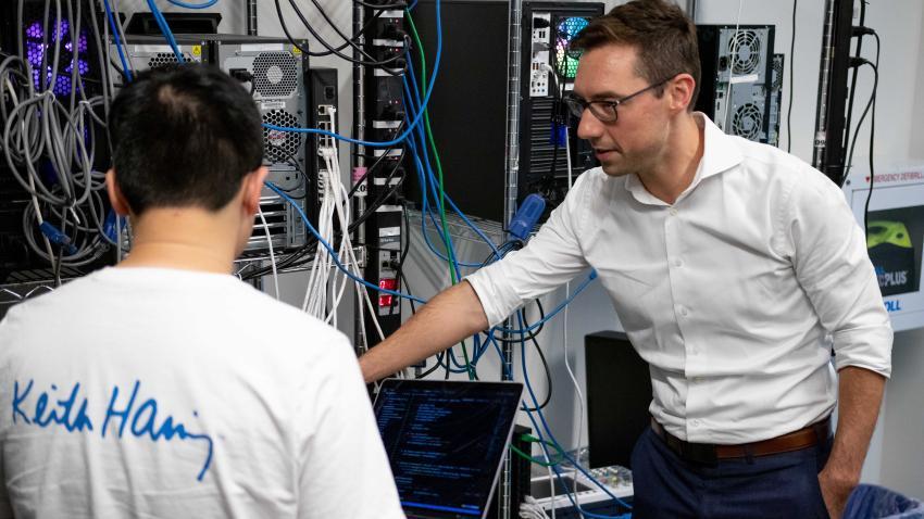 Brendan Saltaformaggio and a PhD student looking at computer hardware