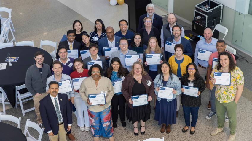 A group of people holding up award certificates