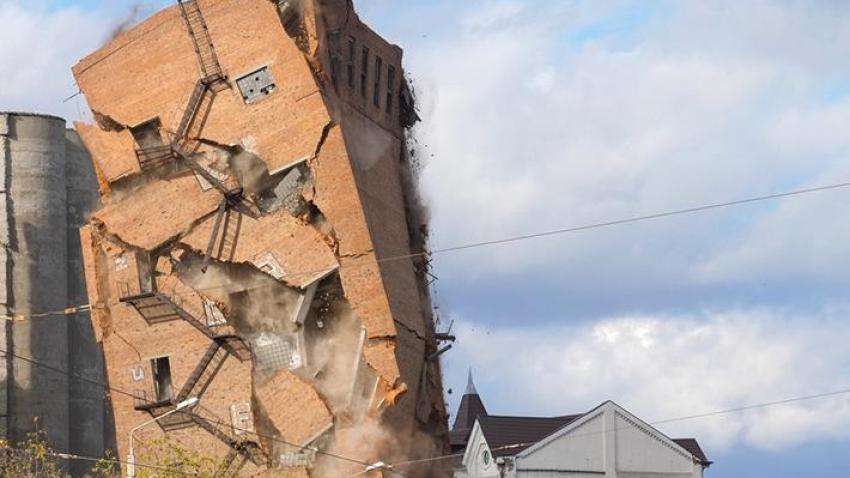 Brick building crumbling and toppling over