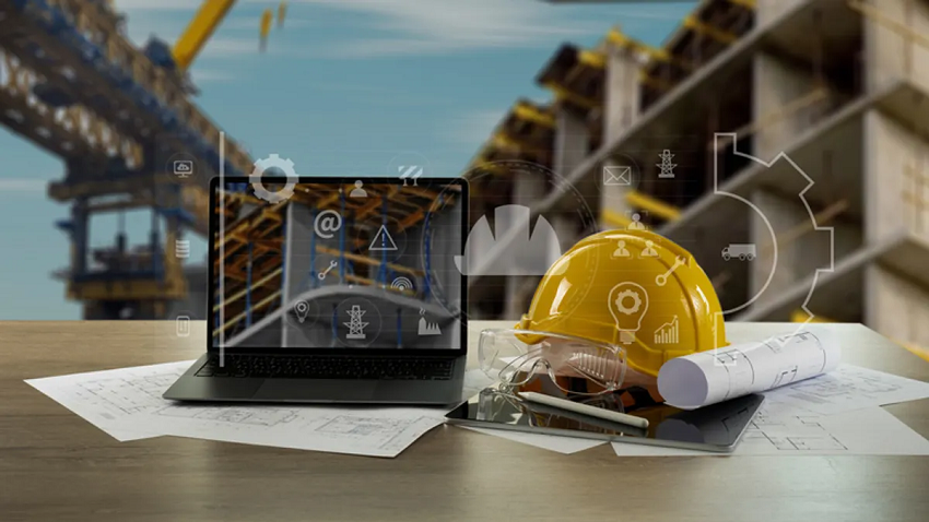 Desk with a laptop and hard hat on it