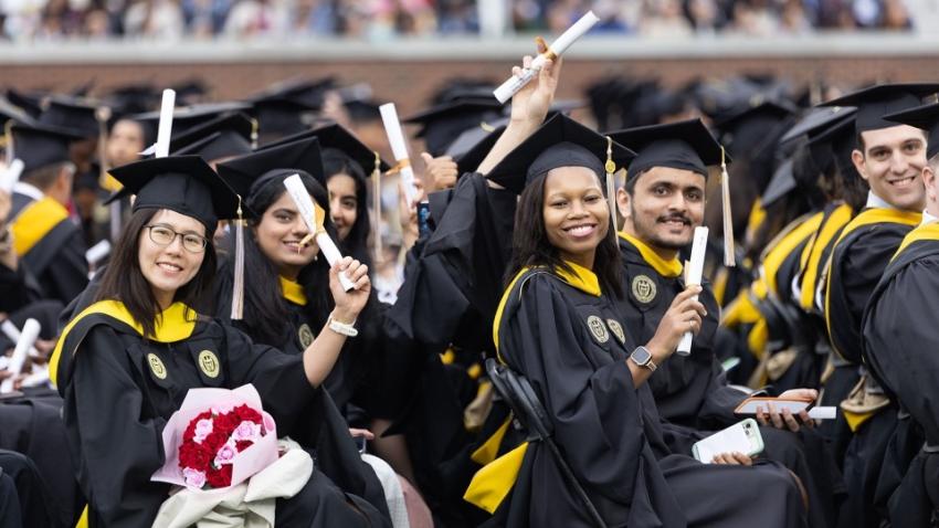College of Computing students at graduation holding diplomas