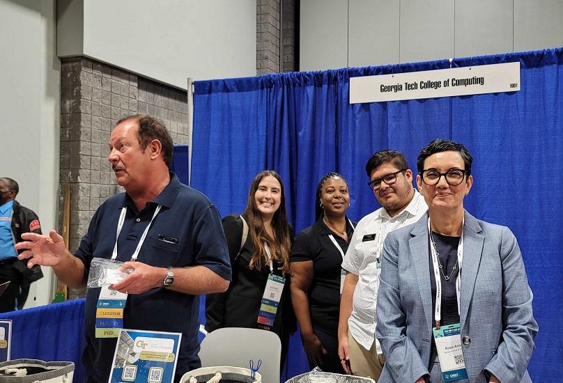 Georgia Tech faculty standing at the College of Computing booth at the Tapia Conference