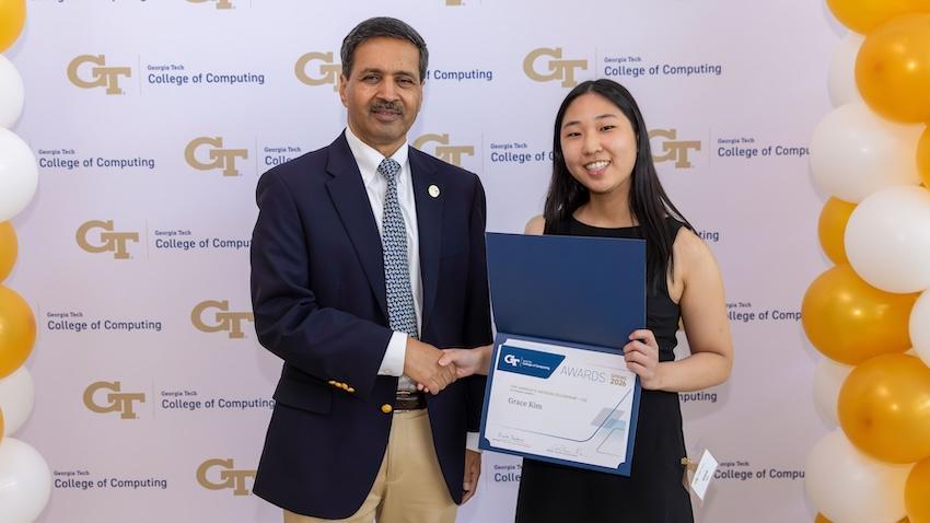 Dean Vivek Sarkar shaking hands with Grace Kim