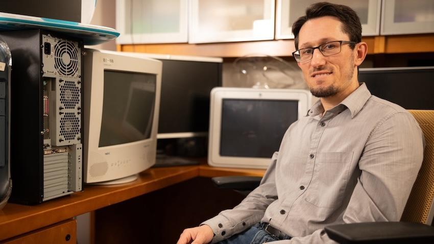 Zsolt Kira in an office surrounded by computers