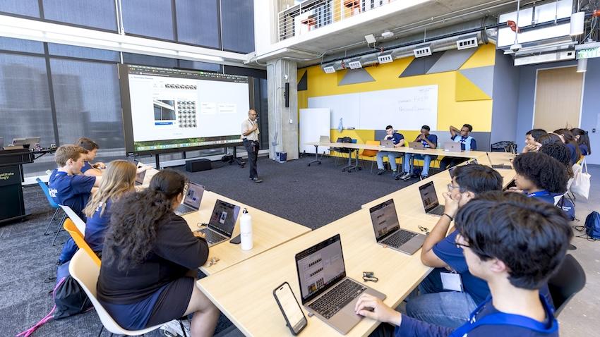 Students in a classroom with their laptops looking at the instructor