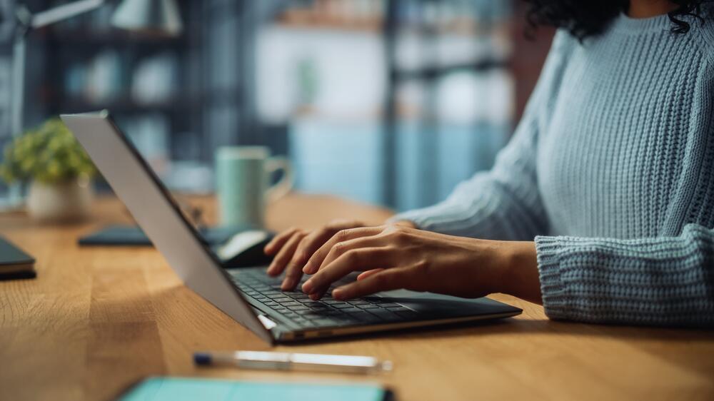 Closeup of hands typing on a laptop